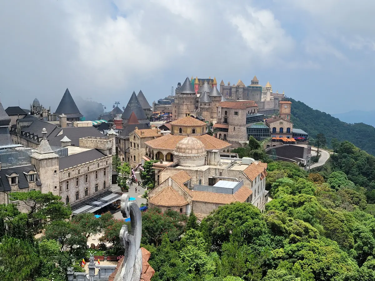 巴拿山山顶小镇的航拍图,石头城堡塔楼和建筑散布在茂密的绿色森林中。