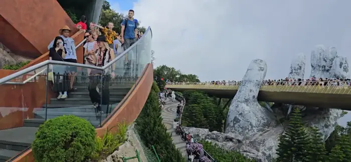 The Golden Bridge at Ba Na Hills under a grey sky.