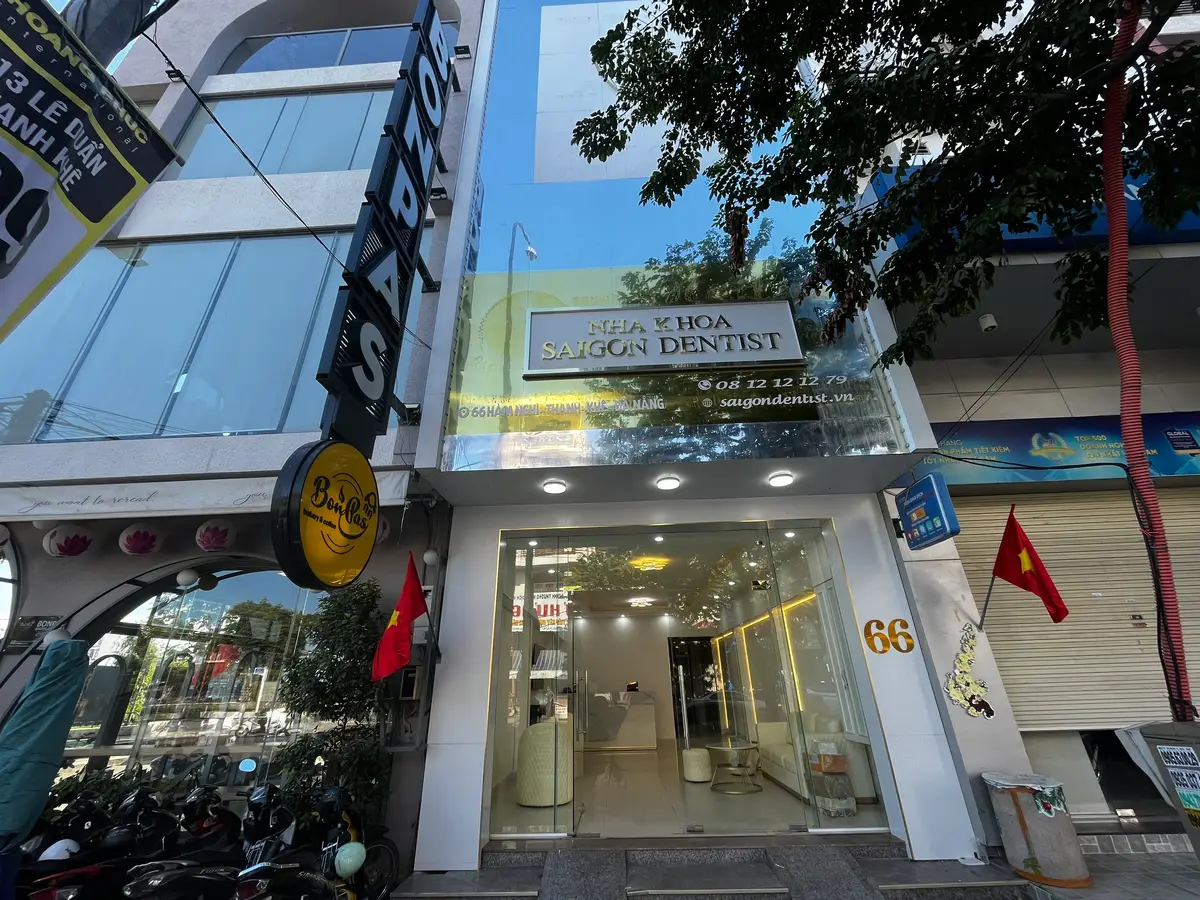 文字の看板の下にあるNha Khoa Saigon Dentistのガラスの入口。中には無人の受付が見えます。