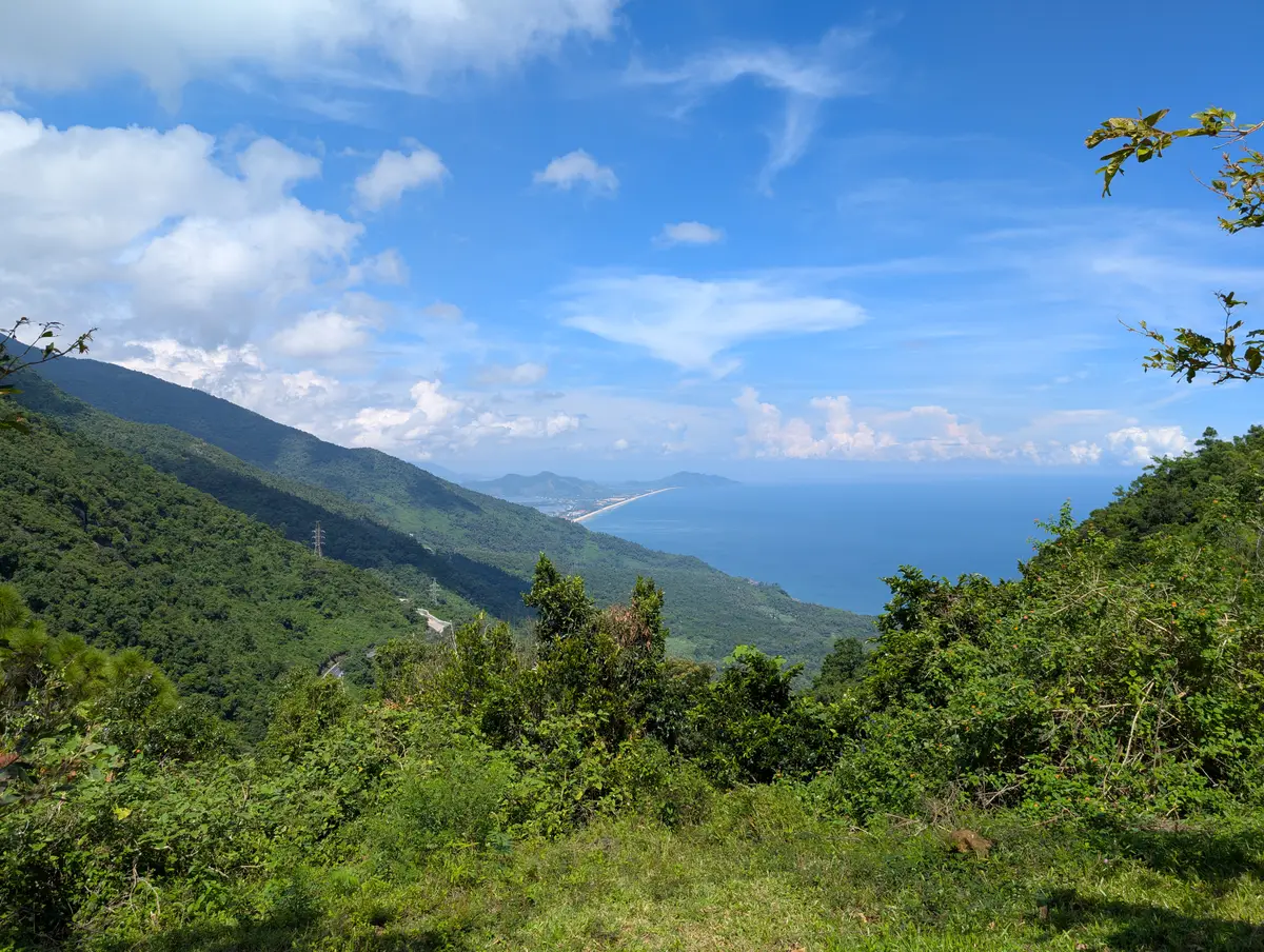 緑の山肌をくねくねと下る舗装された山道と、遠くにかすむ青い海岸線。