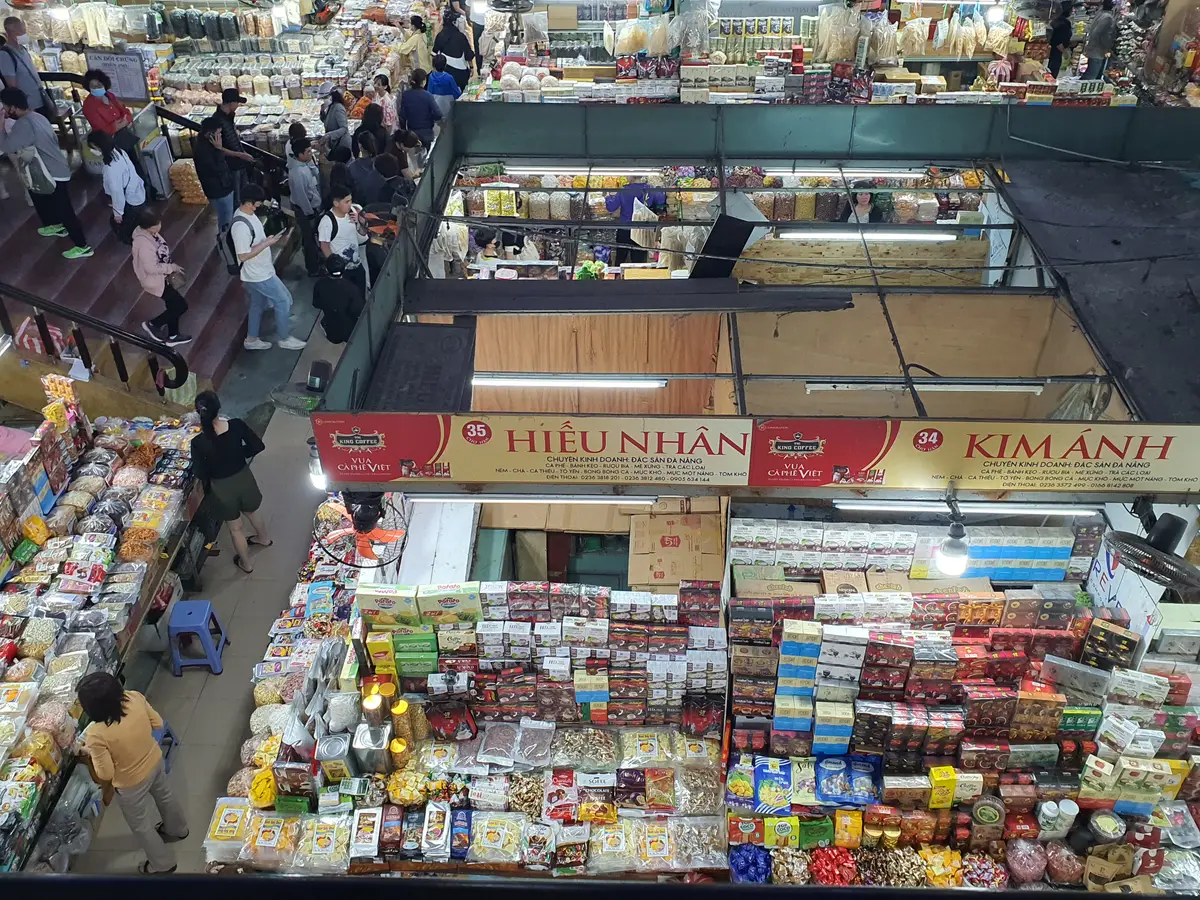 Stalls piled with packaged dried fruit, snacks and sweets under shop signs.