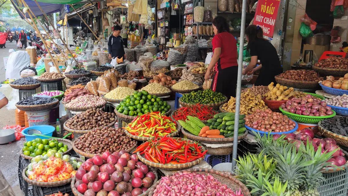 Baskets of chillies, limes, garlic, shallots and other produce spread out at a fresh-food stall.