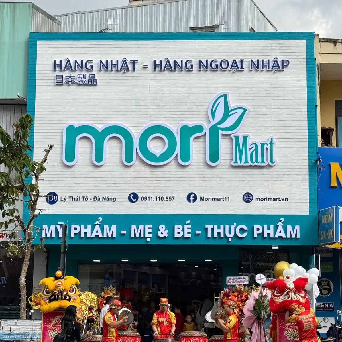 Shop front with a large teal Mori Mart sign above a decorated entrance