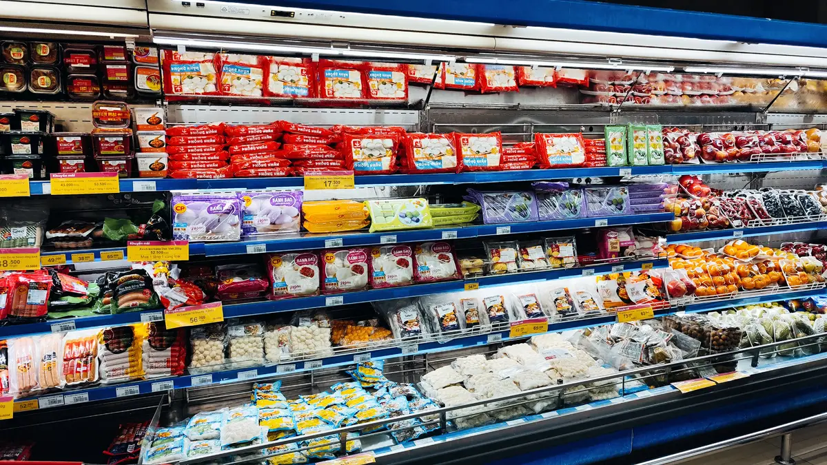 Supermarket shelves stocked with packaged noodles, snacks and groceries