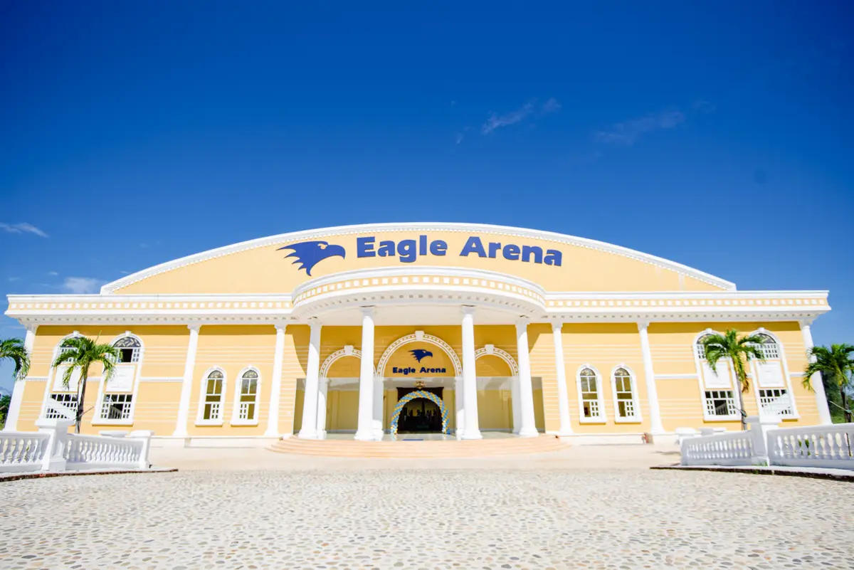 흰 기둥이 있고 정면에 Eagle Arena라고 쓰인 노란색 체육관