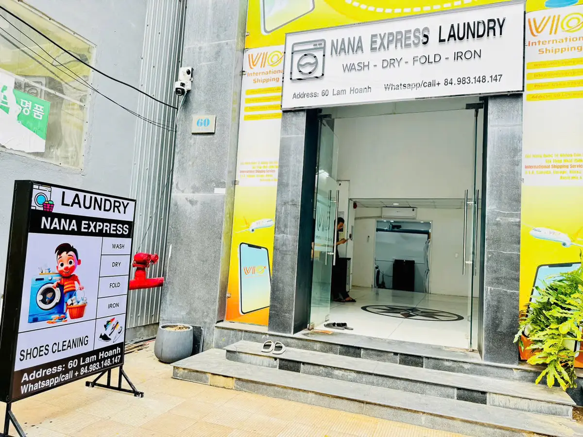 Glass-door laundry shop front with a Nana Express Laundry sign and an A-frame sign outside