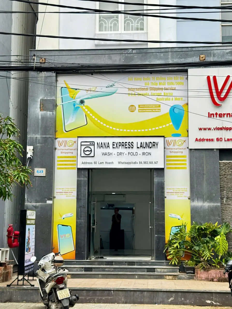 Close view of the yellow and white shop sign reading Nana Express Laundry
