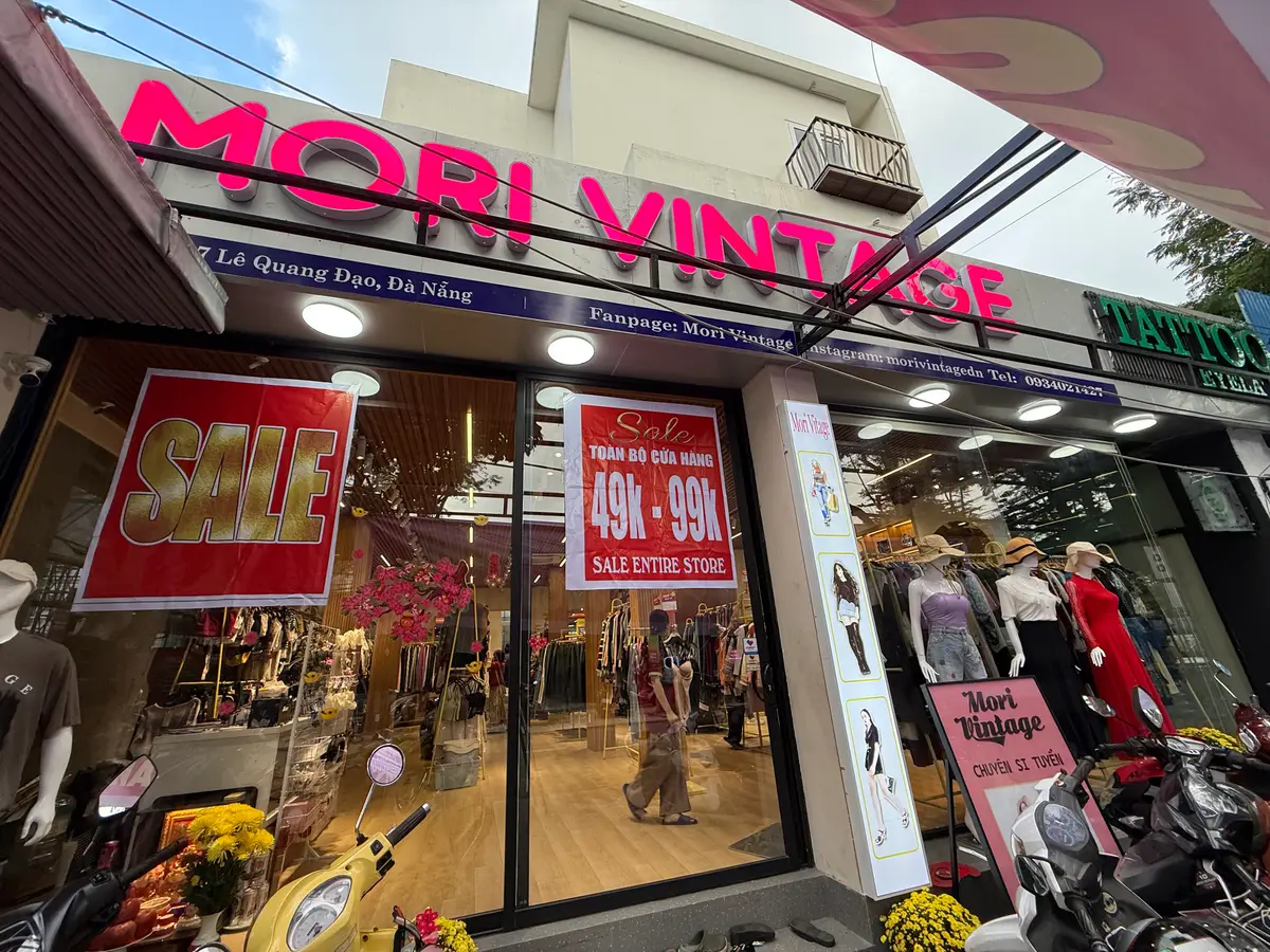 The glass shopfront of Mori Vintage on Le Quang Dao Street with its pink sign and sale posters in the windows.