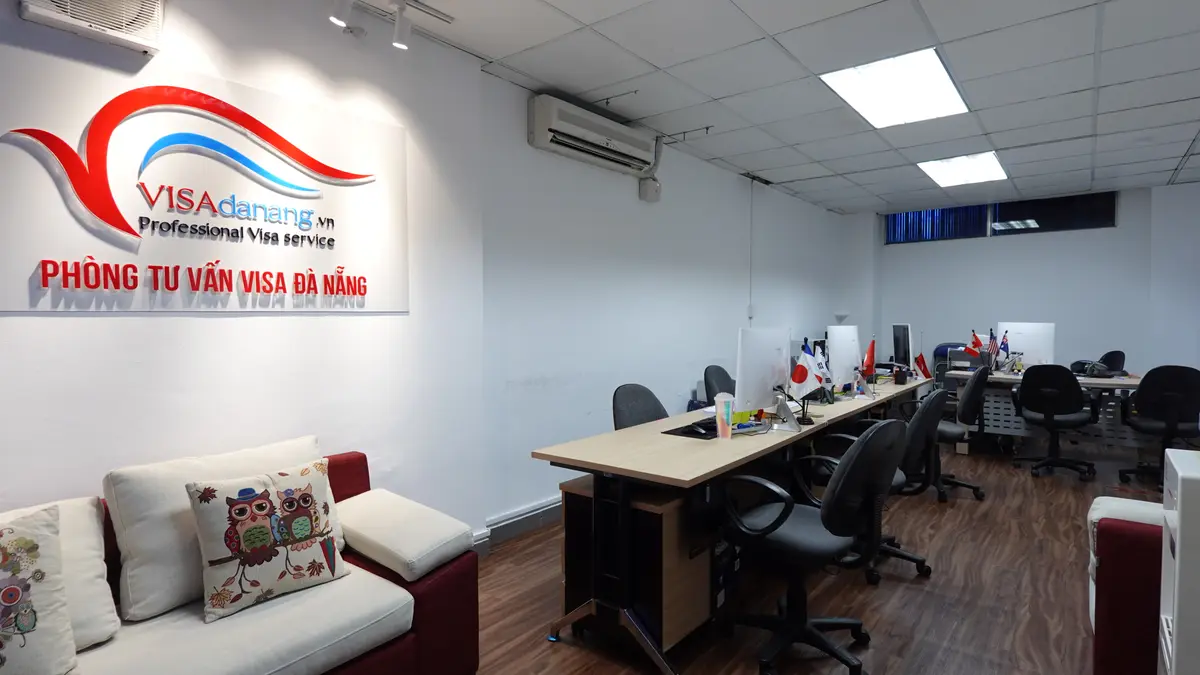 The Visa Danang office: rows of desks and office chairs, a sofa by the door and the company logo on the wall.
