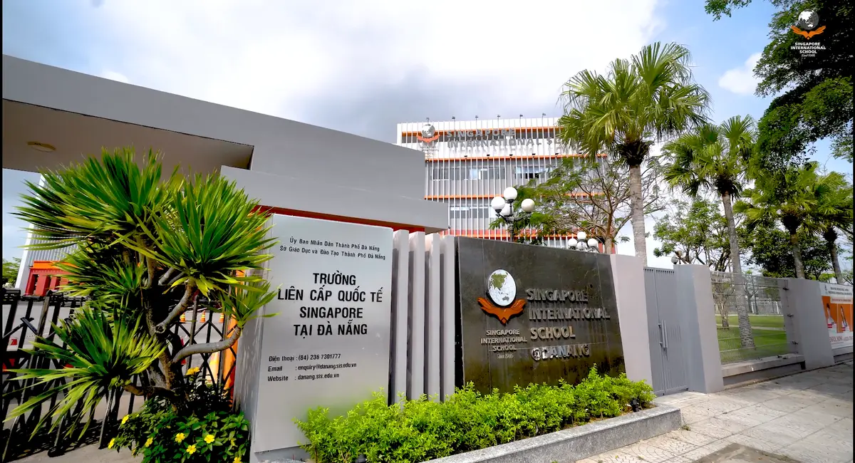 門にあるSingapore International Schoolの看板。生け垣とヤシの木の向こうに校舎があります。